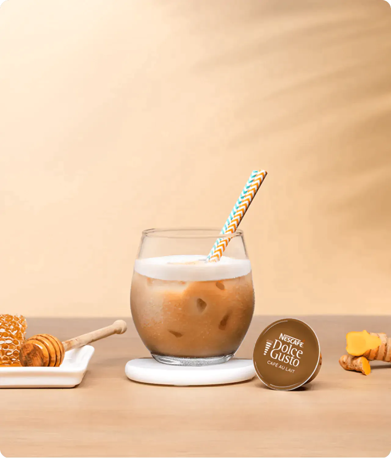 iced latte next to a coffee capsule